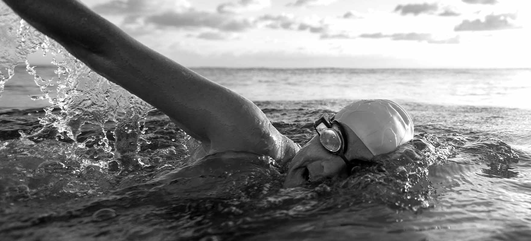 An athlete side breathing while swimming in open water