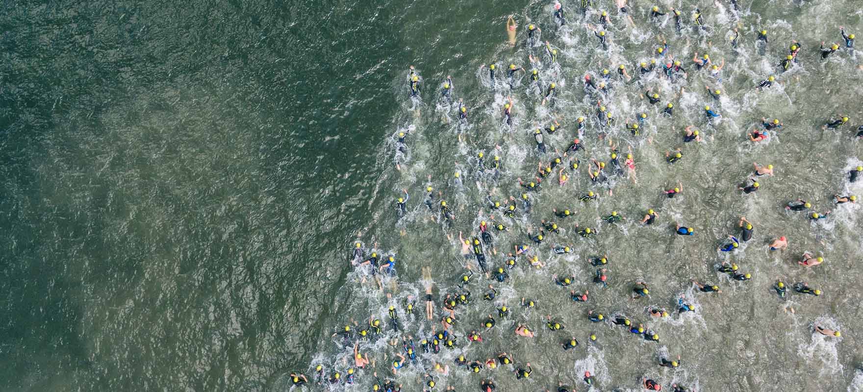Top view of triathlon athletes going to the water