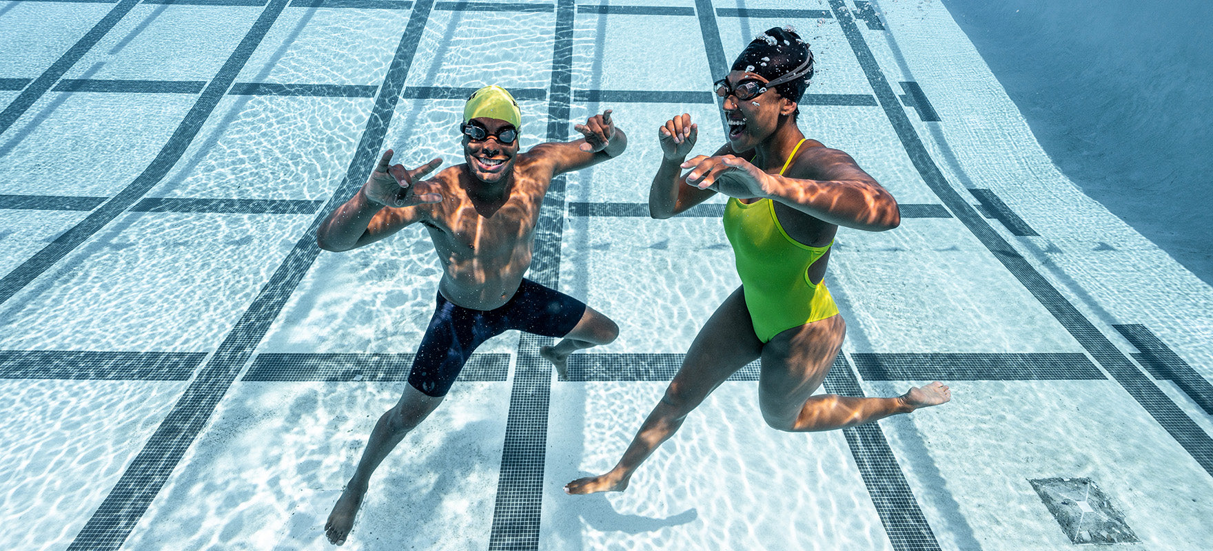 Two swimmers underwater with smart swim goggles