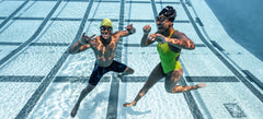 Two swimmers underwater with smart swim goggles
