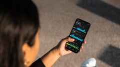A lady holding her phone scrolling through the FORM Swim App