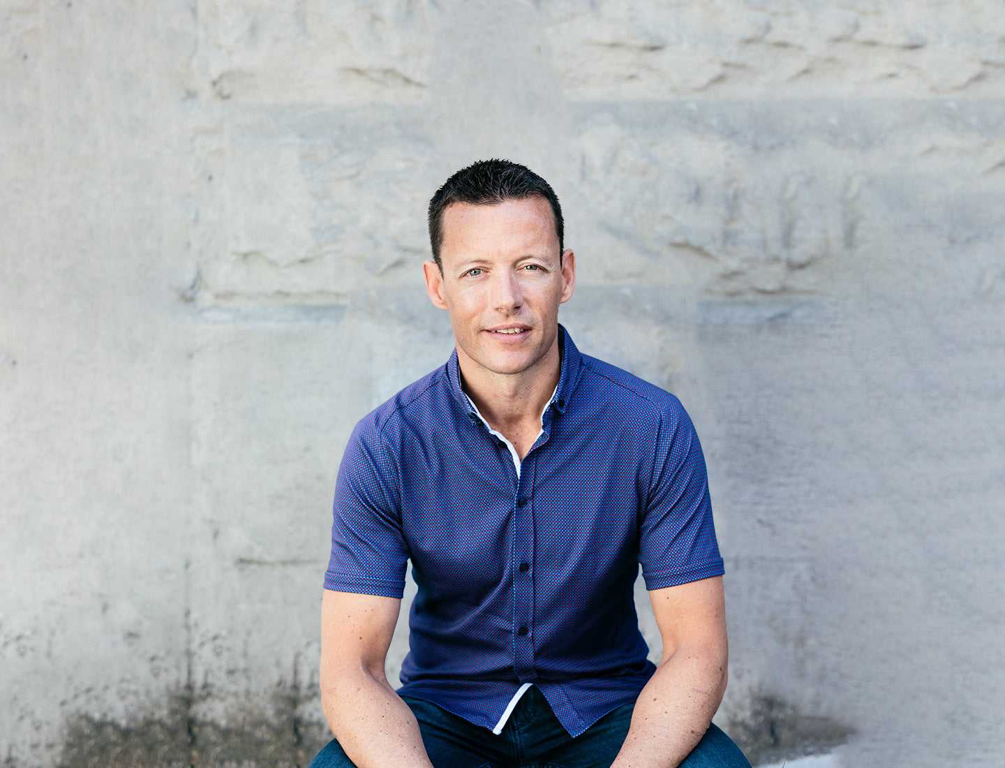 Form CEO Dan Eisenhardt, wearing a blue shirt, sitting down against a concrete wall