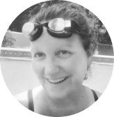 Swim coach Kate Baker smiling and wearing swim goggles on head